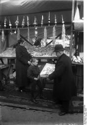  Weihnachtsmarkt in Berlin am Alexanderplatz. Ein Händler mit Christbaumschmuck. 1923
