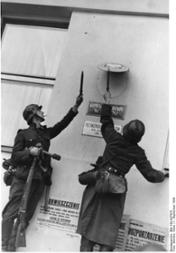 Zwei deutsche Soldaten beim Entfernen des polnischen Hoheitszeichens am ''Regierungskommissariat in Gdynia'' in Gdingen (Gotenhafen), 1. September 1939