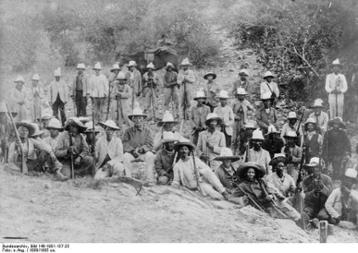 Hendrik Witboi (auf dem Stuhl sitzend) mit Kämpfern des Nama-Stammes, ca. 1904-1905