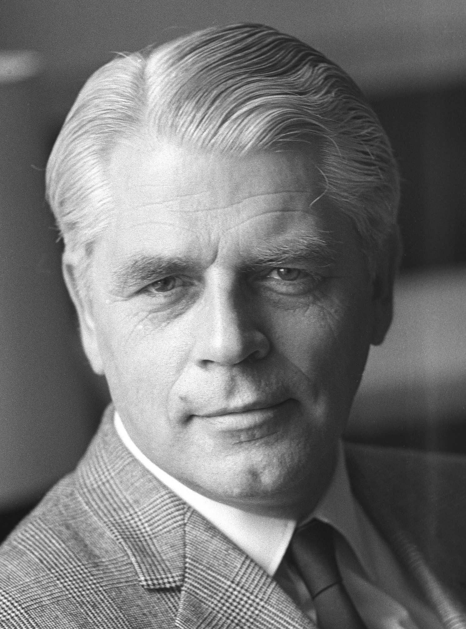 Porträt von Conrad Ahlers (1970) Auf dem Schwarz-Weiß-Porträtfoto ist Conrad Ahlers zu sehen. Er trägt einen Anzug mit kariertem Muster, sowie ein weißes Hemd und eine dunkle Krawatte. Das Foto wurde am 5. Juni 1970 von Jens Gathmann aufgenommen.