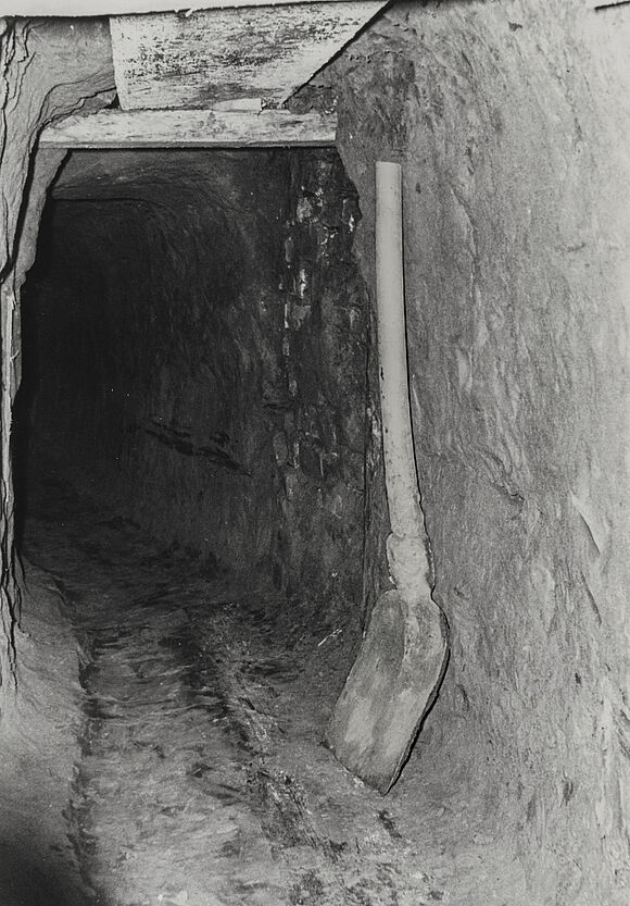 Blick in den Tunnel Richtung West-Berlin. An der Wand der rechten Seite lehnt eine Schaufel.