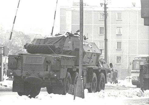 Aufnahme eines großen Militärfahrzeuges, das schwer beladen durch zwei Schranken fährt.