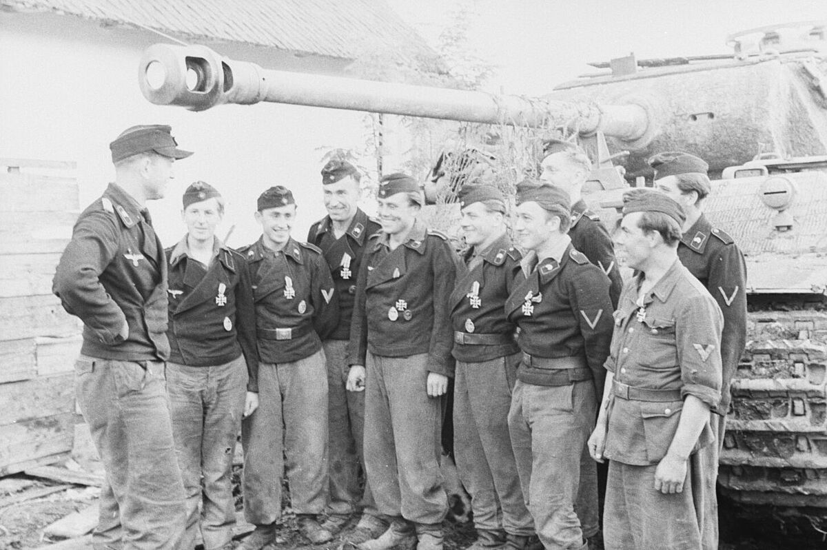Mit Eisernem Kreuz ausgezeichnete Besatzung eines Panzer V „Panther“ vor ihrem Fahrzeug in Litauen stehend