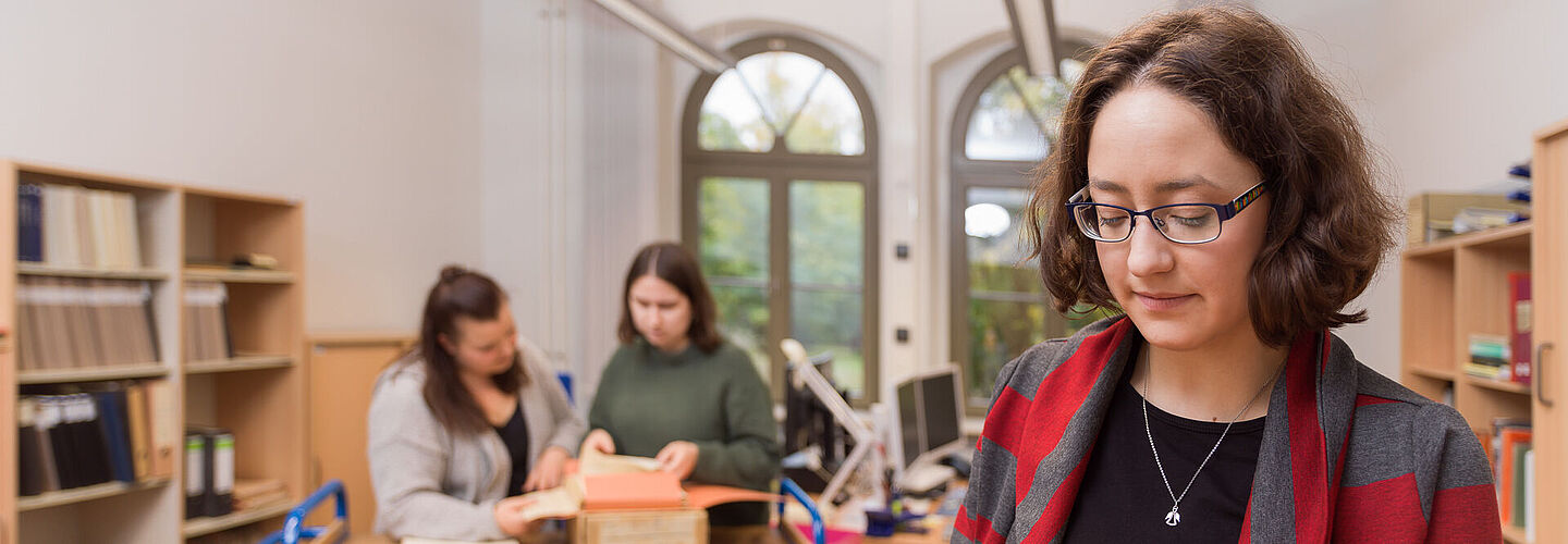 Drei Mitarbeiterinnen des Bundesarchivs prüfen schriftliche Dokumente