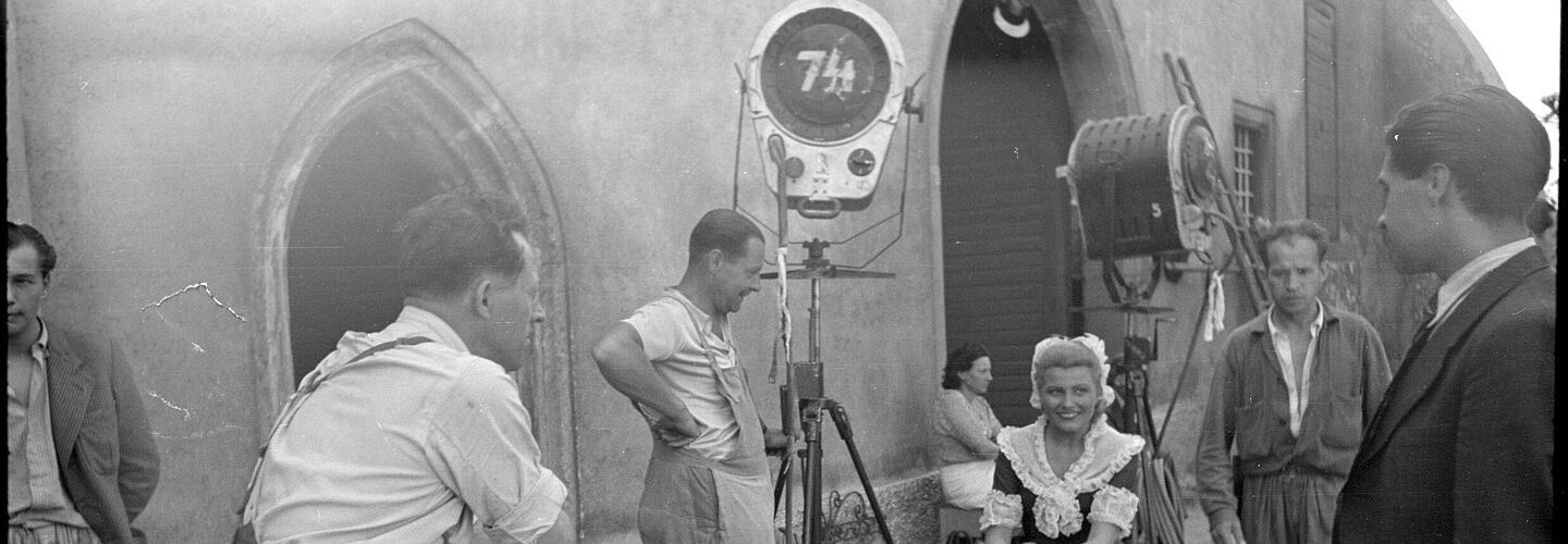 Filmaufnahmen zu 'Wen die Götter lieben' in Wien, Drehpause, Winnie Markus als Constanze Mozart mit Filmcrew, 1942