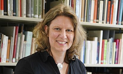 Annette Mertens steht in der Bibliothek des Bundesarchivs an einem Tisch. Vor ihr liegt eine aufgeklappte Akte.