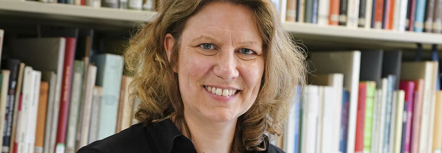 Annette Mertens steht in der Bibliothek des Bundesarchivs an einem Tisch. Vor ihr liegt eine aufgeklappte Akte.