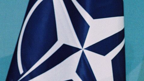 Fahne der NATO: Weiße Windrose vor blauem Hintergrund