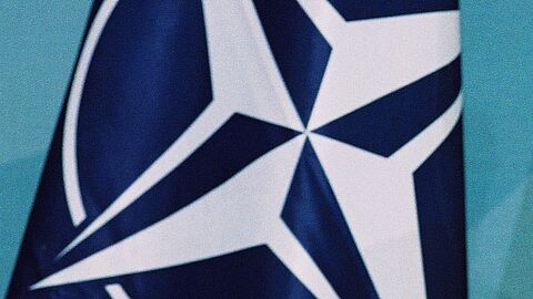 Fahne der NATO: Weiße Windrose vor blauem Hintergrund