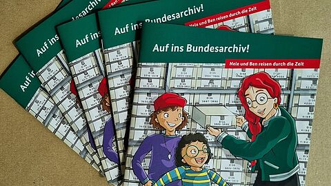 Nahaufnahmen von mehreren Ausgaben des Kinderhefts „Auf ins Bundesarchiv! – Nele und Ben reisen durch die Zeit“