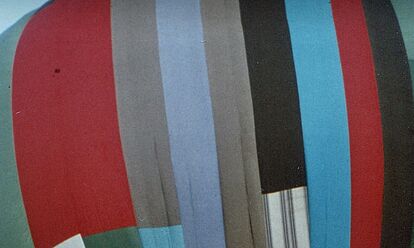 Das Bild zeigt das obere Ende eines Heißluftballons. Der Heißluftballon besteht aus verschiedenen Stoffstücken und ist deshalb bunt.