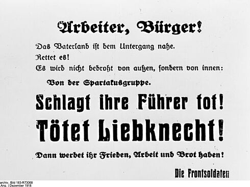 gedrucktes Plakat mit der Aufschrift "Arbeiter, Bürger! Das Vaterland ist dem Untergang nahe. Rettet es! Es wird nicht bedroht von außen, sondern von innen: Von der Spartakusgruppe. Schlagt ihre Führer tot! Tötet Liebknecht! Dann werdet ihr Frieden, Arbeit und Brot haben! Die Frontsoldaten!"