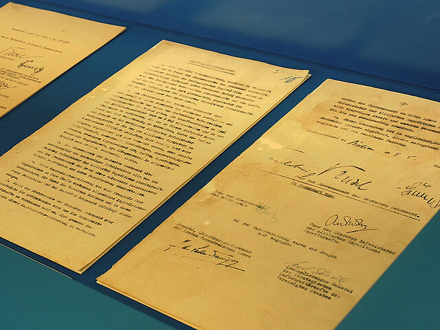 Gelbliche Dokumente auf türkisblauem Untergrund