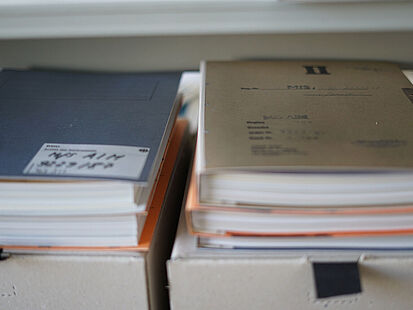 Beispielakten Zwei Stapel Beispielakten liegen auf Kartons.