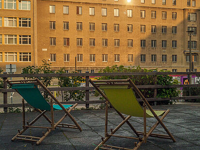 Blick auf "Haus 7" mit zwei Liegestühlen im Vordergrund.