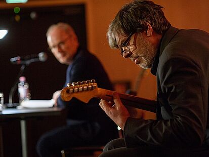 Reinhold Beckmann und der ihn musikalisch begleitende Gitarrist während der Lesung