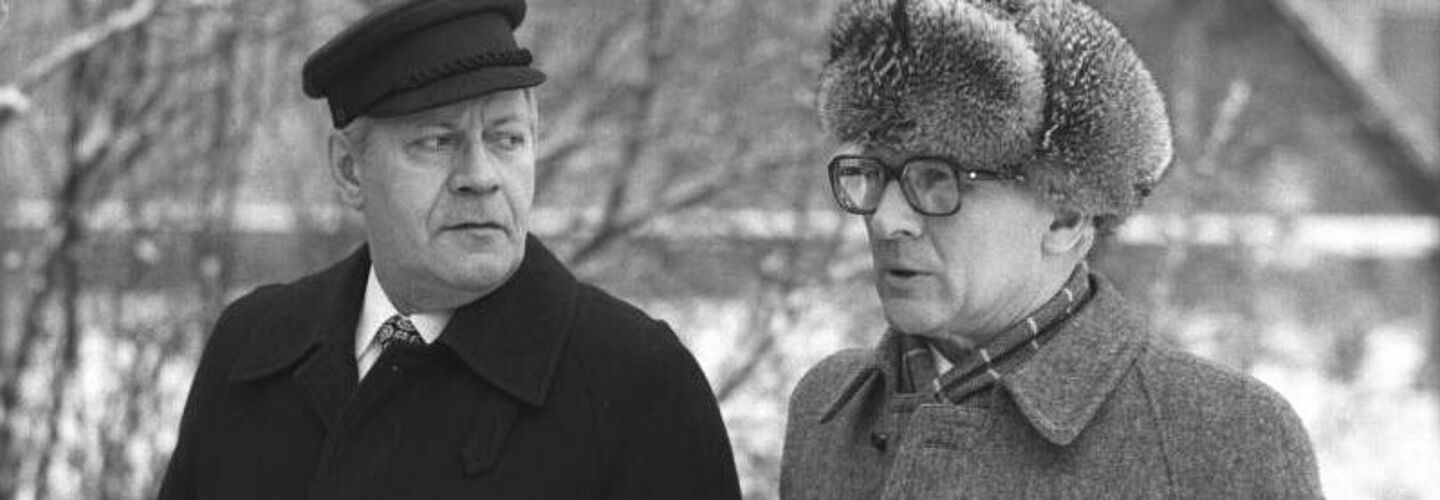 Schwarz-Weiß-Foto von Helmut Schmidt und Erich Honecker in Mänteln bei einem Winterspaziergang