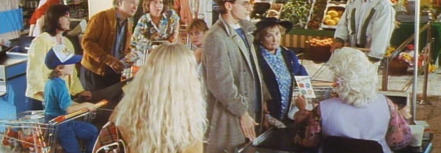 Ausschnitt aus dem TV-Sport „Supermarkt“, Teil einer AIDS-Präventionskampagne der ehemaligen Bundeszentrale für gesundheitliche Aufklärung (BzgA) von 1990 Ausschnitt aus dem TV-Sport „Supermarkt“, Teil einer AIDS-Präventionskampagne der ehemaligen Bundeszentrale für gesundheitliche Aufklärung (BzgA) von 1990. Das Foto zeigt meherere Menschen an einer Supermarkt-Kasse.