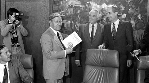 Foto in Schwarz-Weiß von der letzten Sitzung des Kabinetts von Bundeskanzler Helmut Schmidt (2.v.l.): Übergabe des ersten Bandes der Kabinettsprotokolle der Bundesregierung des Jahres 1949 