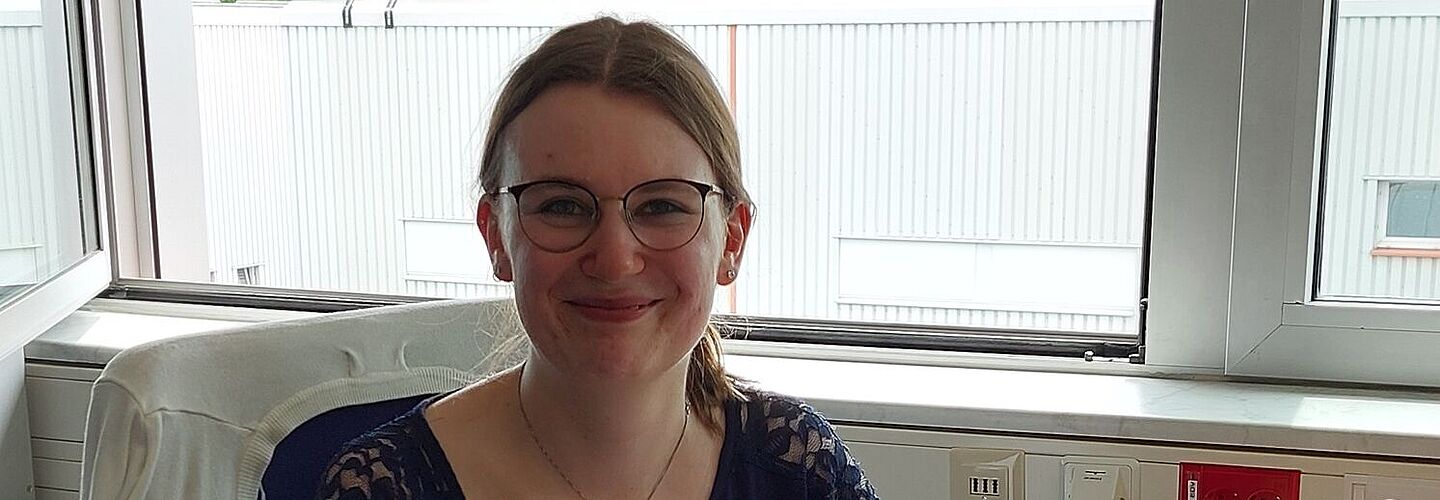 Carmen Lotzmann sitzt an ihrem Arbeitsplatz, vor ihr liegt eine aufgeklappte Akte.