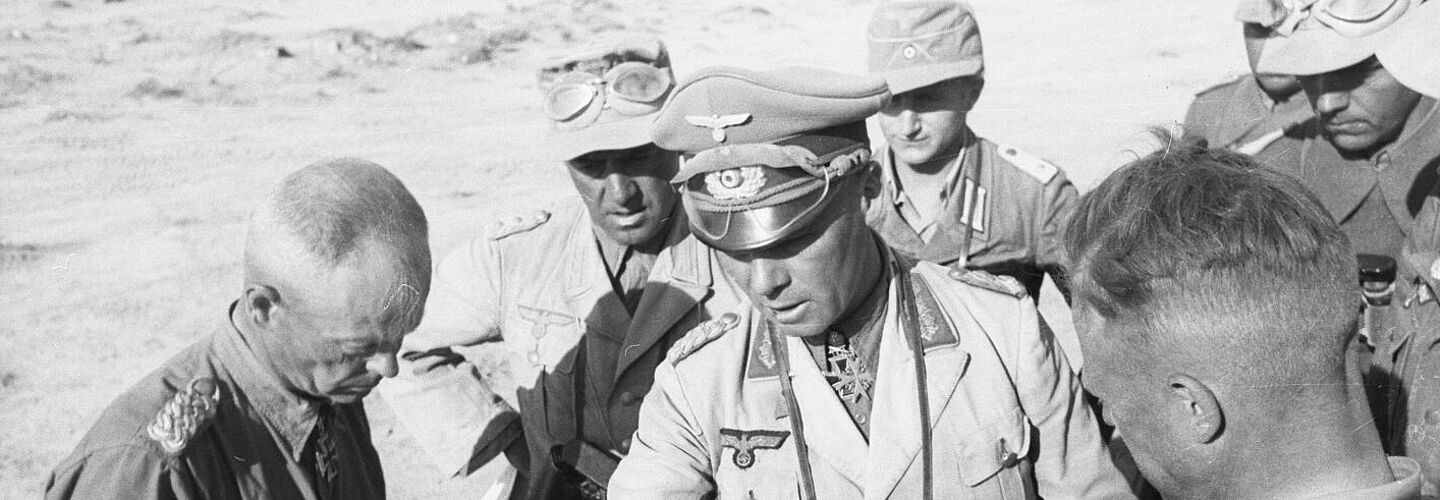 Sieben Offiziere beugen sich über eine Karte