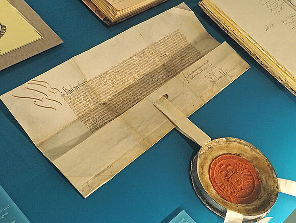 Halb geöffnete Dokument mit großem Wachssiegel