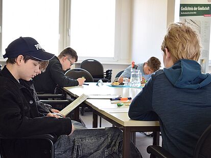 Girls‘ und Boys‘ Day 2026 im Bundesarchiv Vier Jungen sitzen an einem Tisch und beschäftigen sich mit einem Aufgabenblatt