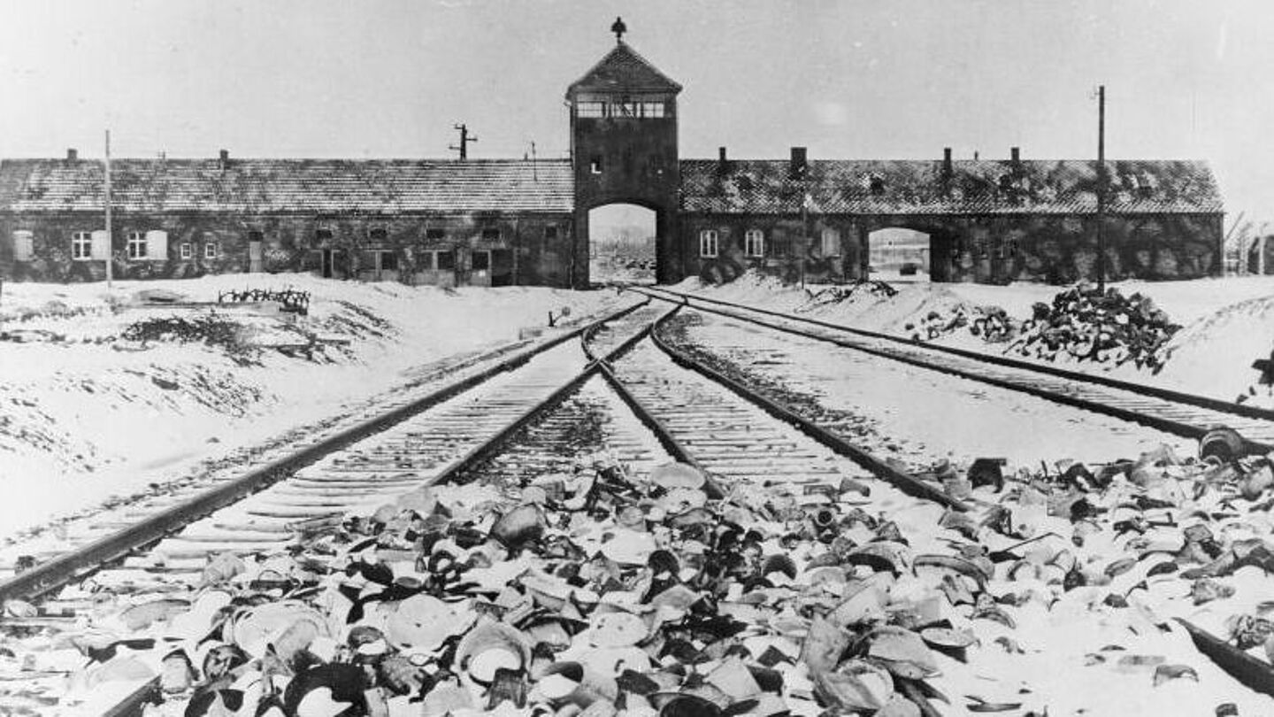 Das Schwarzweißfoto zeigt den Eingang des Konzentrations- und Vernichtungslager Auschwitz-Birkenau nach der Befreiung durch sowjetische Soldaten, Quelle:
            BArch, B 285 Bild-04413 / Mucha, Stanislaw