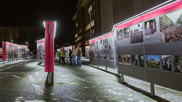 Open-Air-Ausstellung 'Revolution und Mauerfall' der Robert-Havemann-Gesellschaft auf dem Gelände der 'Stasi-Zentrale. Campus für Demokratie' bei Nacht.