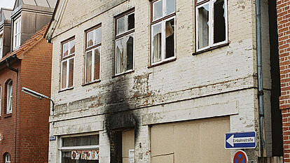 Möllner Bürger vor dem ausgebrannten Wohnhaus, in dem bei einem Brandanschlag durch rechtsextremistische Täter drei Türkinnen ums Leben kamen