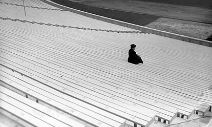 Eine Frau auf den leeren Zuschauerrängen des Olympiastadions