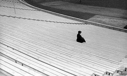 Eine Frau auf den leeren Zuschauerrängen des Olympiastadions