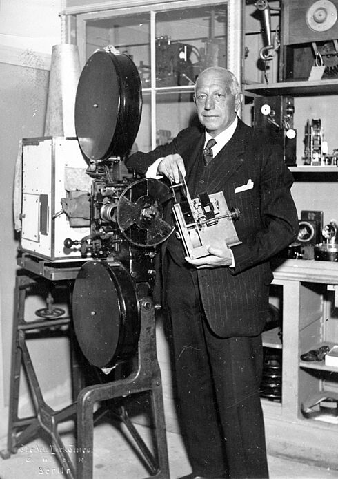 Porträtaufnahme von Oskar Messter an einer Filmkamera