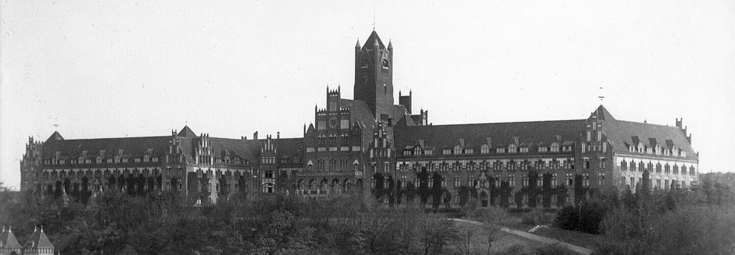 Blick auf ein langes Gebäude an einem Gewässer