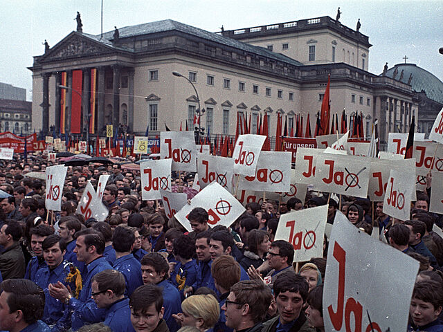 Kundgebung zum Volksentscheid über die Verfassung der DDR vor der Staatsoper, im Vordergund Angehörige der FDJ.