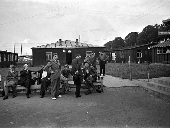 Flüchtlinge vor den Baracken des Notaufnahmelagers Gießen