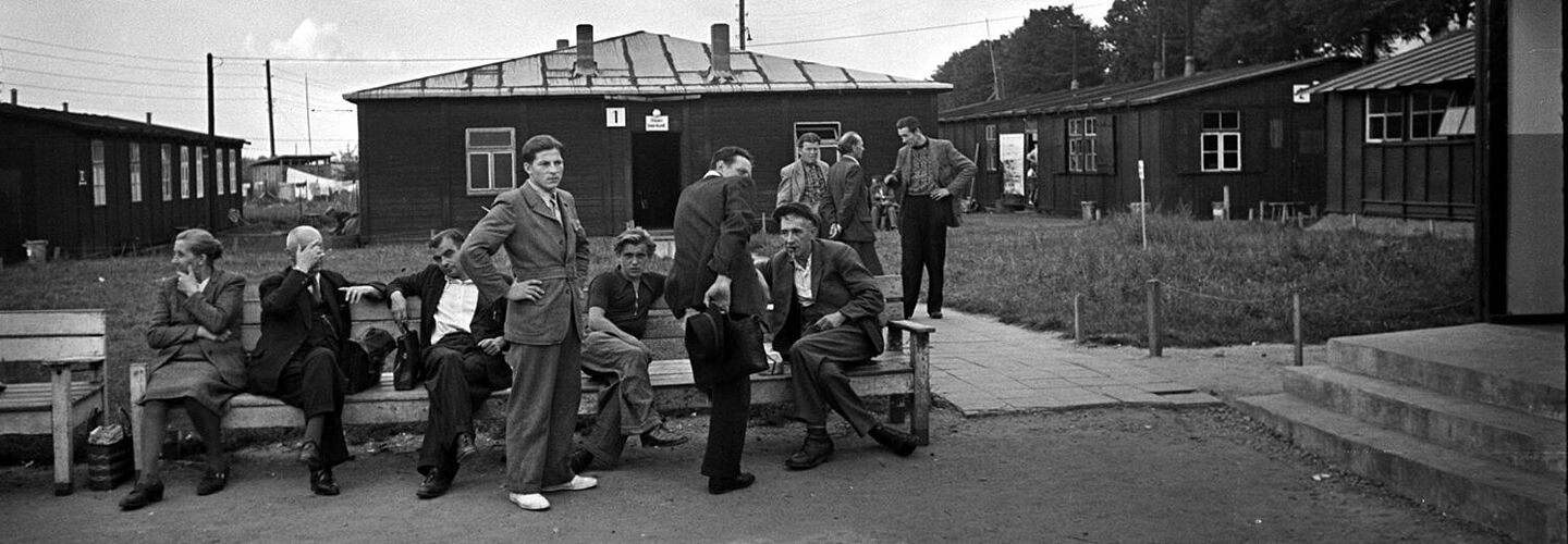 Flüchtlinge vor den Baracken des Notaufnahmelagers Gießen