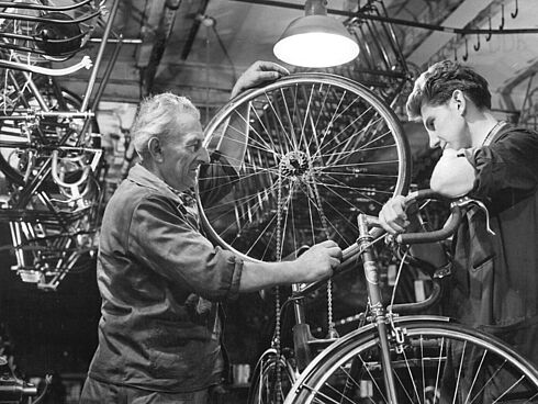 Zwei Männer setzen ein Rennfahrrad zusammen.