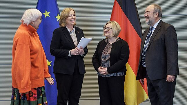 Claudia Roth, Bärbel Bas, Alexandra Titze und Michael Hollmann im Empfangsraum des Deutschen Bundestags. Bärbel Bas hält den Tätigkeitsbericht des Bundesarchivs in den Händen.