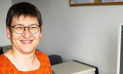 Sabine Herrmann sitzt an ihrem Arbeitsplatz, vor ihr liegt eine aufgeklappte Akte.