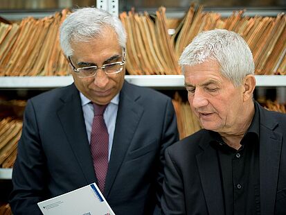 Prof. Cannataci und Roland Jahn zwischen Regalen mit IM-Akten im Stasi-Unterlagen-Archiv. 