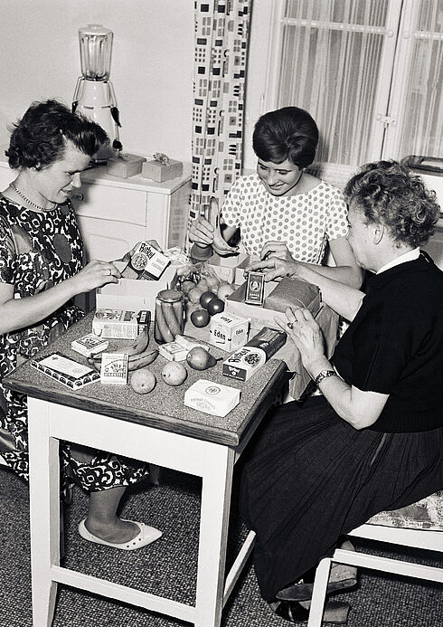 Familien packen am Jahrestag des Mauerbaus Päckchen für Freunde und Bekannte im Osten.