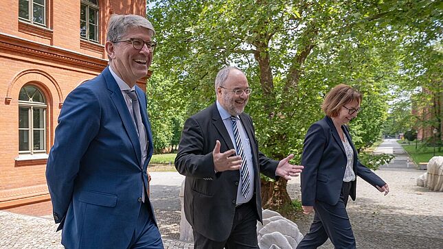 Wolfram Weimer, Michael Hollmann und Andrea Hänger laufen vor dem Bundesarchiv-Standort Berlin-Lichterfelde vor Gebäuden.