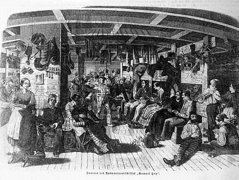 Zeichnung einer Gruppe Frauen und Männer, die in einem größeren, mit Holz verkleideten Kojenraum an Bord eines Schiffes in die USA sitzen