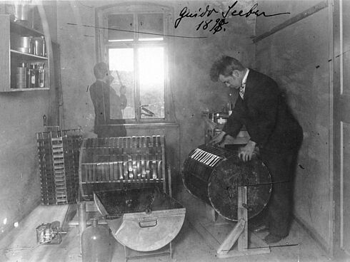 Guido Seeber in einem Fotoatelier während der Arbeit an der Filmtrockentrommel und an der Kamera