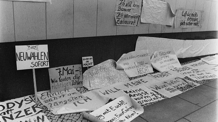 Auf einer Demonstration fordern Bürgerinnen und Bürger auf Plakaten Wahlfreiheit.