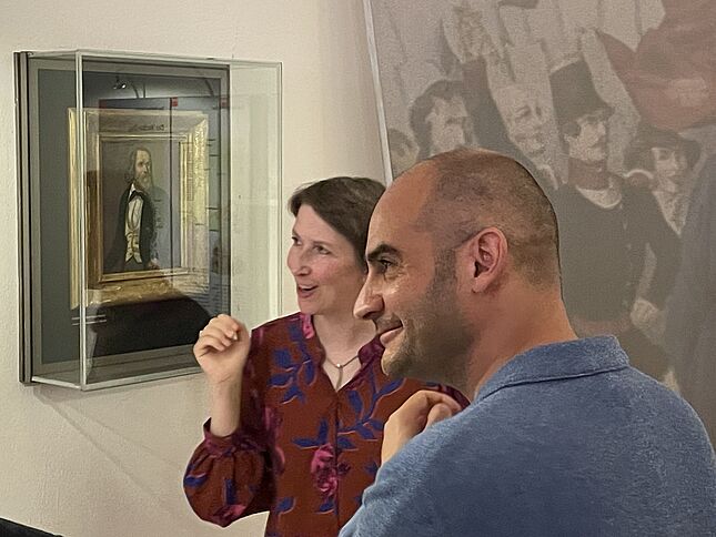 Bild wie Dr. Elisabeth Thalhofer Minister Bayaz das Heckerbild in der Dauerausstellung zeigt