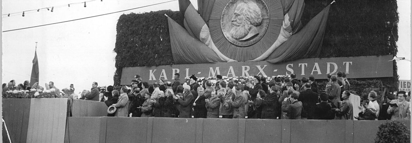 Menschen auf einer Tribüne während der Feierlichkeiten am 11. Mai 1953 im Rahmen der Umbenennung von Chemnitz in Karl-Marx-Stadt Menschen auf einer Tribüne während der Feierlichkeiten am 11. Mai 1953 im Rahmen der Umbenennung von Chemnitz in Karl-Marx-Stadt