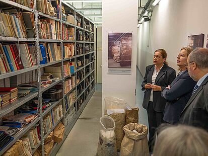Abteilungsleiterin Birgit Salamon, Bundestagspräsidentin Bärbel Bas und Bundesarchiv-Präsident Michael Hollmann (v.l.n.r.) vor einem Aktenregal