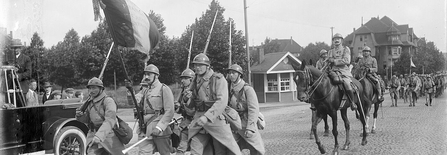 Abrücken der letzten französischen Soldaten aus Essen an der Ruhr: Marschierende Soldaten mit französischer Flagge
